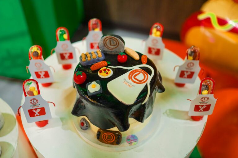 A vibrant chef-themed cake decorated with edible miniatures and aprons, perfect for culinary celebrations.
